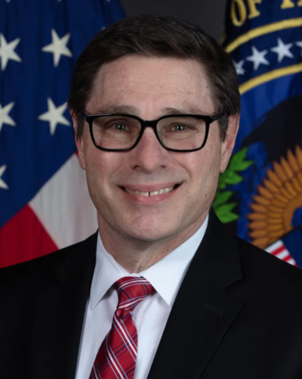 A person wearing glasses and a suit

Description automatically generated with low confidence